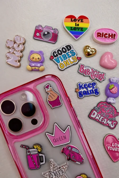 Rosa mobilskal med färgglada charms.