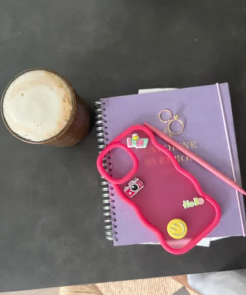 Mobilskal med charms i kontorsmiljö.