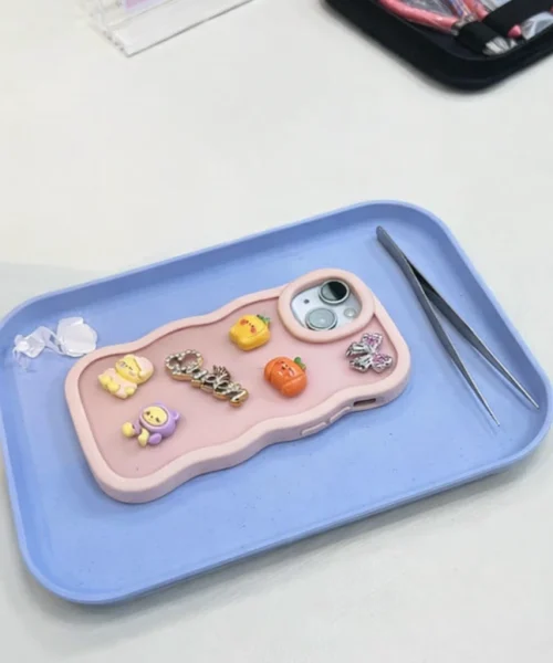 Designat mobilskal med charms.