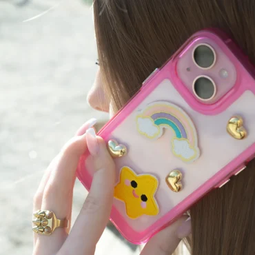 Tjej pratar i telefon med rosa mobilskal.