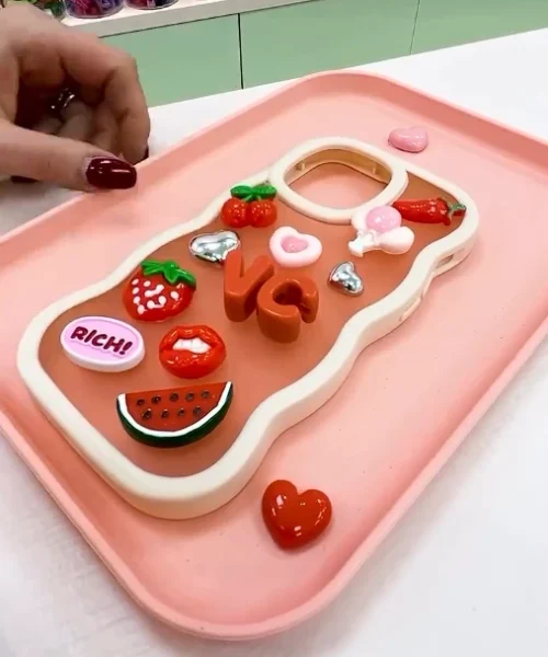 Designat mobilskal med charms.